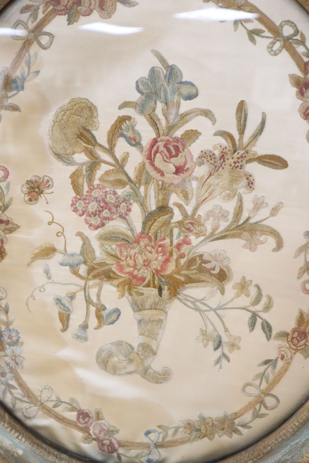 An early 19th century silkwork panel of flowers in a cornucopia, oval 50 x 42cm